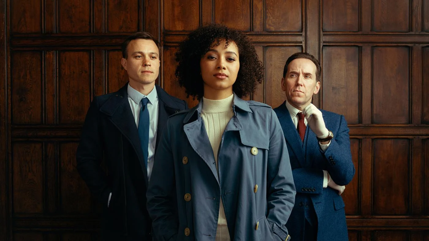 Dan and Professor T look at Lisa in front of them in a portrait